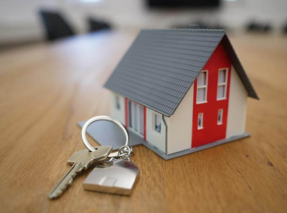property keys and small house on company desk