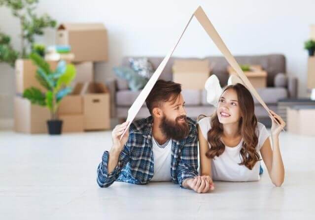 a happy young married couple moves to new apartment